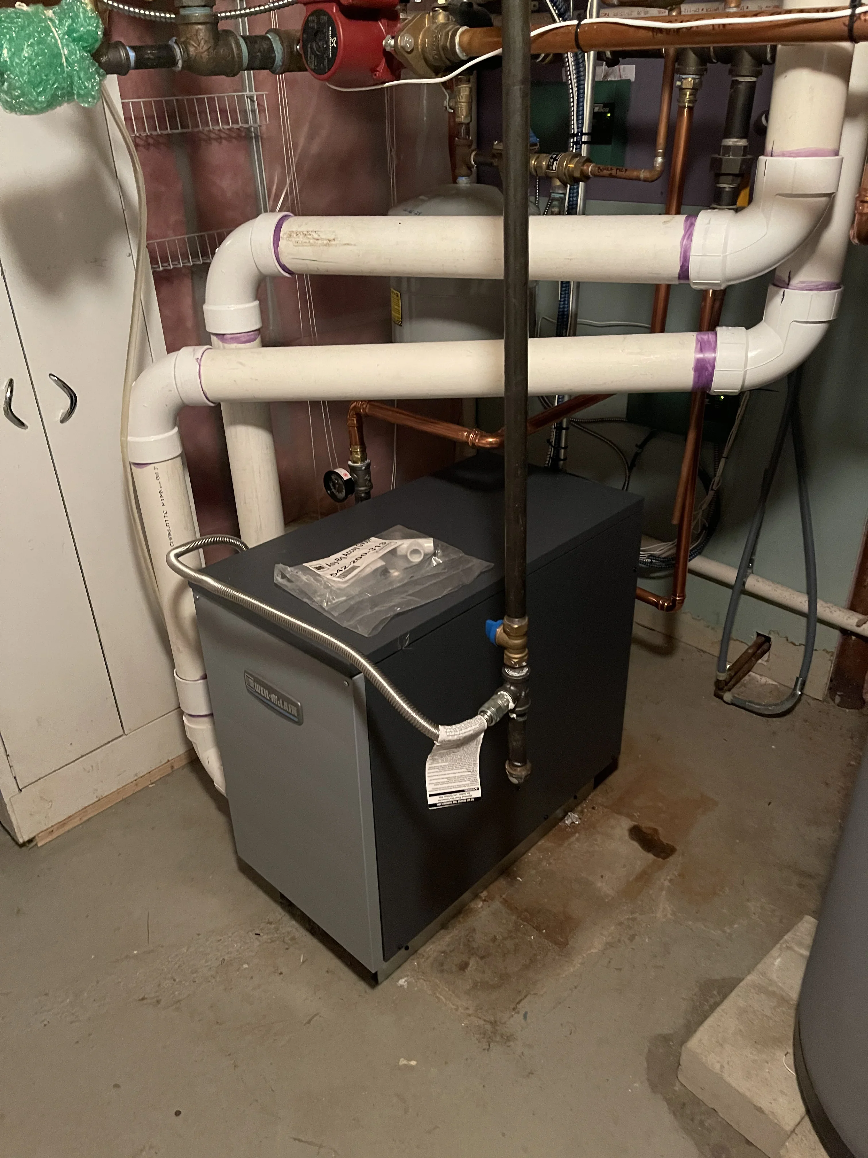 New furnace with white PVC ductwork, copper lines, and sealed connections in basement mechanical room